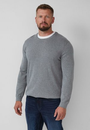 Grauer Pullover mit Rundhalsausschnitt und langen Ärmeln, aus weichem Stoff gefertigt. Er hat gerippte Bündchen und einen weißen inneren Kragen, kombiniert mit blauen Jeans.