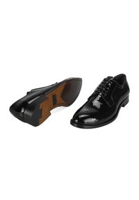 Chaussures habillées en cuir noir avec une finition brillante, bout rond, design à lacets, semelle extérieure brune contrastante et talon plat.
