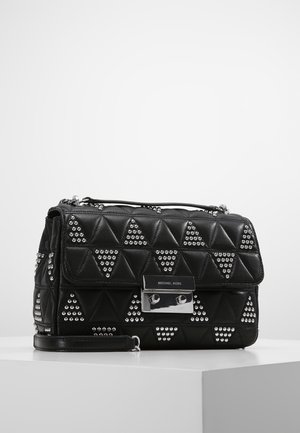 Czarna pikowana skórzana torebka z srebrnymi trójkątnymi ćwiekami, srebrną zapinką z grawerem "Michael Kors" oraz odpinanym paskiem na nadgarstek.