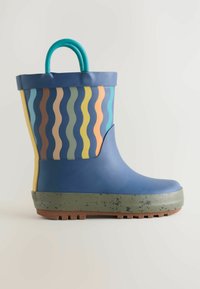 Gummiregenstiefel mit blauem Körper, wellenmuster in mehreren Farben, gelben Akzenten und einer grünen strukturierten Sohle. Verfügt über einen gebogenen Griff an der Oberseite.