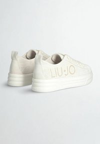 Sneaker in suede beige e rete con punta arrotondata, lacci piatti e marchio "LIU·JO" in rilievo sul lato. Suola bianca spessa.
