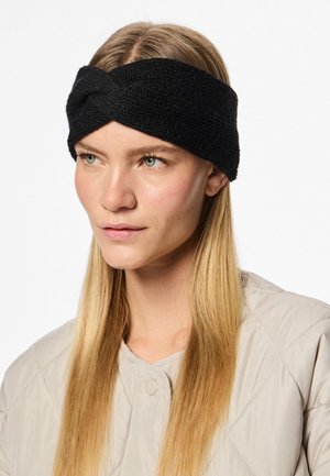 Svart stickad pannband med en tvinnad design, texturerad yta och bred silhuett, buren av en modell med rakt hår.