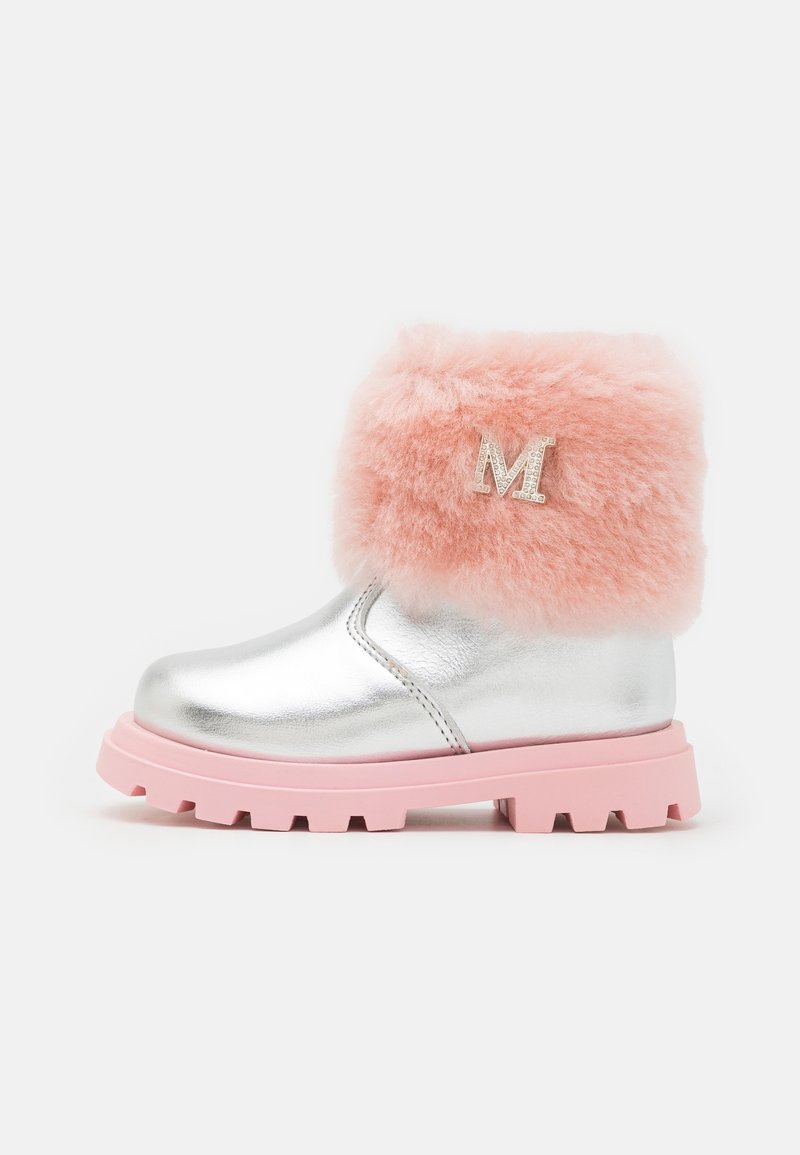 Botas metálicas plateadas hasta el tobillo con puño de piel sintética rosa y emblema M en el lateral. Presentan una suela rosa resistente y una superficie suave, proporcionando un aspecto distintivo.
