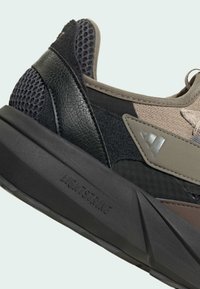 Baskets présentant un mélange de matériaux, notamment du mesh, du cuir et du daim ; les couleurs incluent le noir, le marron et le gris ; accents texturés et marquage "LIGHTSTRIKE".