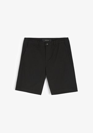 Czarne bawełniane szorty o gładkiej fakturze, z zapięciem na guzik, bocznymi kieszeniami i przeszytymi brzegami. Zaprojektowane z myślą o codziennym użytkowaniu.