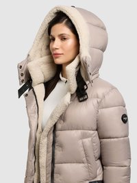 Giacca a vento beige chiaro con cappuccio imbottito e fodera cremosa e morbida. Presenta dettagli neri e chiusura con cerniera, con una texture trapuntata.