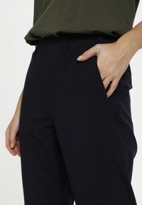 Marina stretchbyxor med en slät textur, med sidfickor och en skräddarsydd design. Midjebandet är platt för en ren finish.