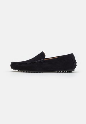 Marineblå ruskinds loafers med en syet detalje over vamps, gummisål med små nubber for godt greb, klassisk og strømlinet form.