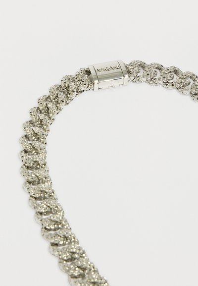 Colar de corrente prateada com elos texturizados e fecho de segurança, refletindo luz com um acabamento polido.