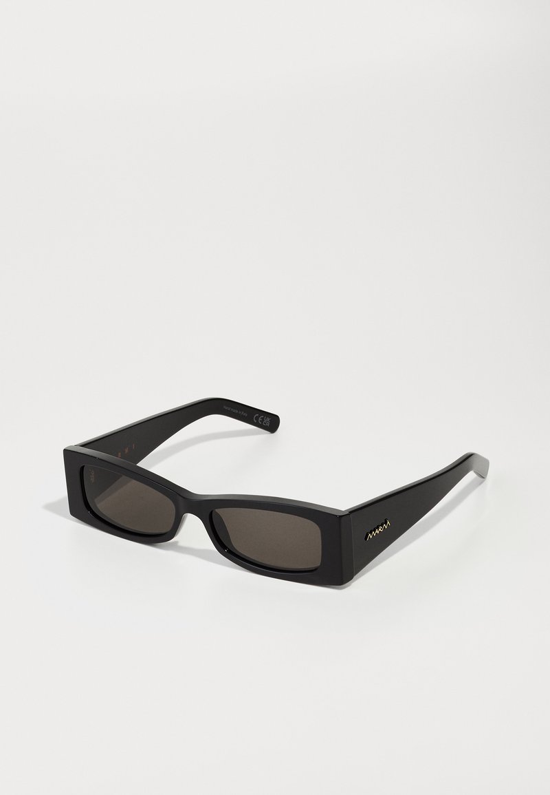 Μαύρα ορθογώνια γυαλιά ηλίου με σκούρες φακούς, πλατύ πλαστικό σκελετό, λεπτούς βραχίονες και χρυσό λογότυπο στο πλάι.