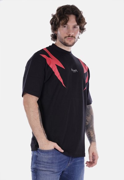 T-shirt nero a maniche corte con grafiche di fulmini rossi e logo sul petto. Realizzata in cotone, presenta un collo tondo e una vestibilità rilassata.