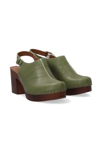 Groene leren klompen met een verstelbare enkelband, ronde neus, dikke houten hak en contrasterende stiksels op het bovenwerk.