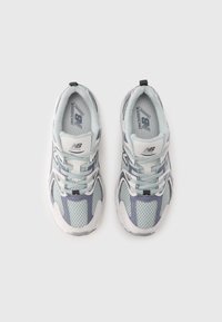 Light blue and grey running shoes with mesh upper, lace closure, padded collar, and rubber sole; features logo detailing on tongue and side.