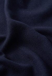 Tessuto a maglia blu navy con una superficie morbida e testurizzata, caratterizzato da un motivo a coste e una leggera caduta. Ideale per abbigliamento o tessuti caldi.