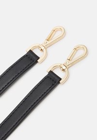 Cinturino in pelle nera con elementi in metallo dorato, caratterizzato da una texture liscia e cuciture a contrasto lungo i bordi.