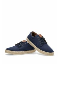 Zapatos de lona azul marino con suela de esparto texturizada, que presentan detalles en cuero marrón y cordones negros. Punta redondeada y diseño de caña baja.