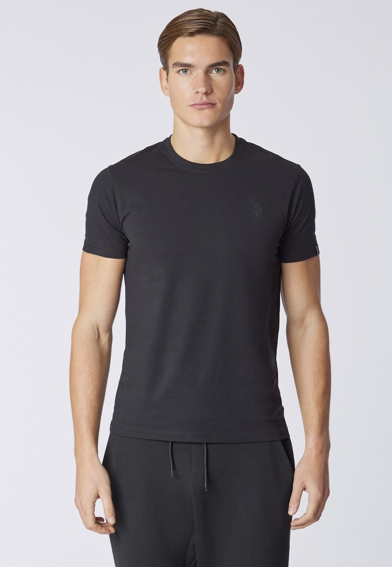 T-shirt nera in cotone con collo rotondo e maniche corte, caratterizzata da un logo ricamato discreto sul petto e una silhouette aderente.