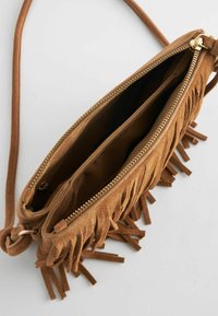 Borsa a tracolla in suede marrone con dettagli frangiati, chiusura con zip e due scomparti interni. Presenta una texture morbida e un design sottile.