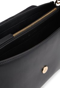 Černé kožené psaníčko se zipovým uzávěrem, zlatým kováním, hladkou texturou a jedním magnetickým zapínáním. Vnitřek není podšitý.
