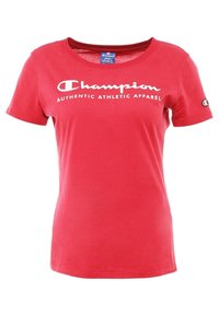 Červené tričko s krátkým rukávem vyrobené z bavlny, s bílým logem "Champion" a textem "AUTHENTIC ATHLETIC APPAREL" přes hrudník.