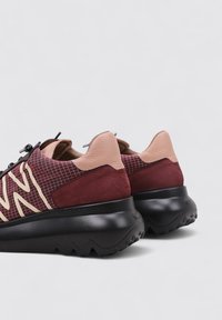 Baskets marron et beige avec une tige en cuir texturé et en mesh, semelle intermédiaire noire, motif de semelle en zigzag, arborant un grand logo "W".