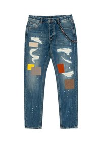 Vaqueros de mezclilla azul con corte slim, que presentan parches desgastados, acentos de tela multicolor y sutiles manchas de pintura en las piernas.
