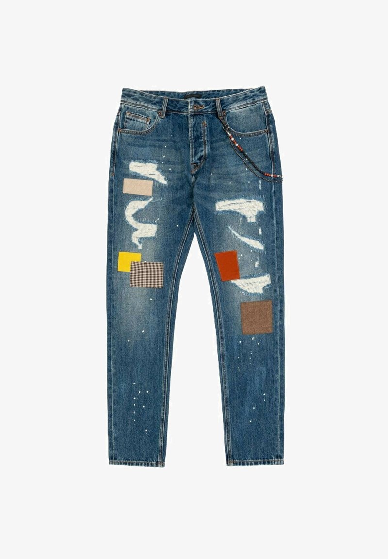 Jeans in denim blu con una vestibilità slim, caratterizzati da toppe strappate, dettagli in tessuto multicolore e sottili schizzi di vernice sulle gambe.