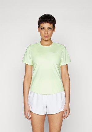 Tricou sportiv verde deschis, cu mâneci scurte și decolteu rotund, asortat cu pantaloni scurți albi. Țesătura pare netedă și ușoară.