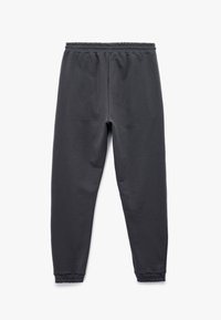 Donkergrijze, katoenen joggerbroek met een elastische tailleband, aansluitende boorden en een gladde textuur. Eenvoudig ontwerp zonder extra kenmerken.