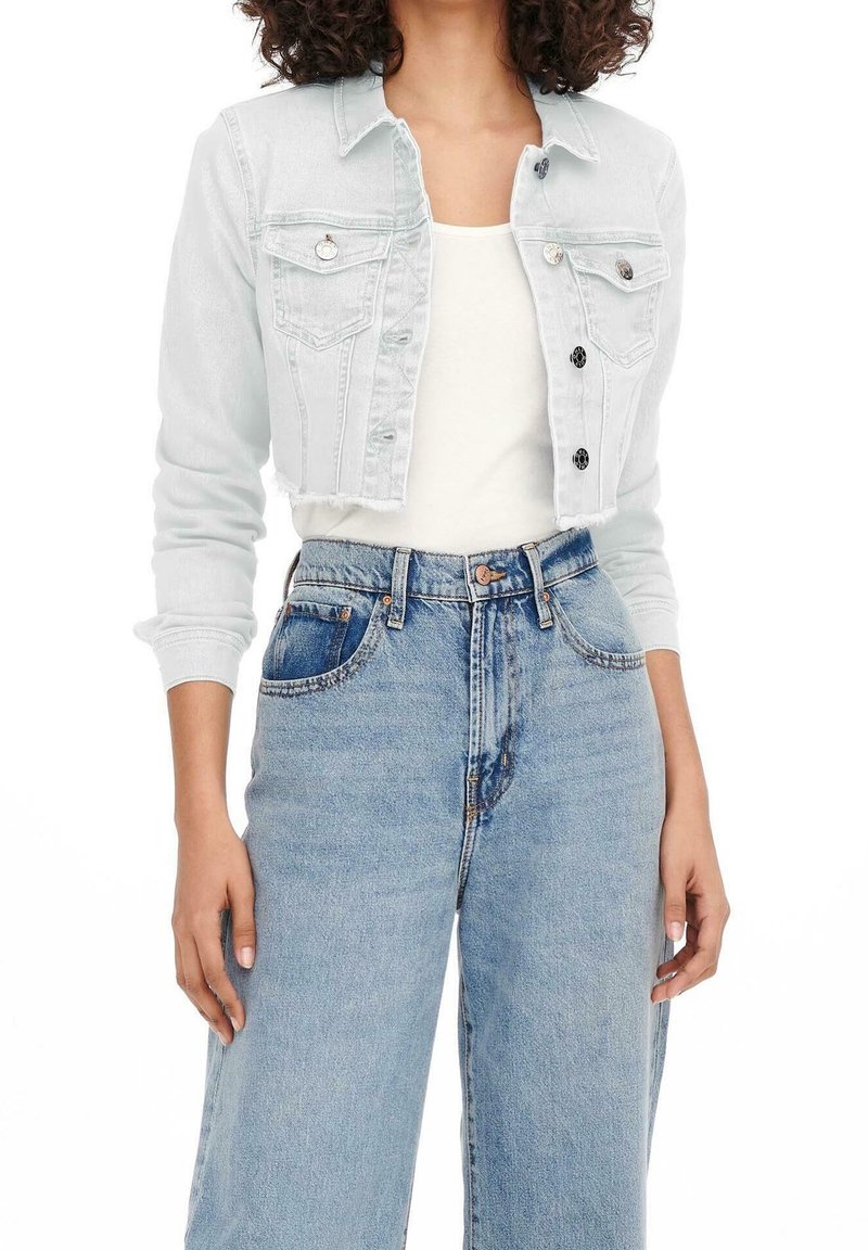 Ljusblå kort denimjacka med knäppning fram, två bröstfickor och rå fåll, kombinerad med högmidjade blåjeans.