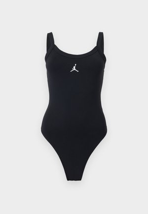 Czarny jednoczęściowy strój kąpielowy z szerokimi ramiączkami i białym logo Jumpman na środku klatki piersiowej na jednolitym tle.