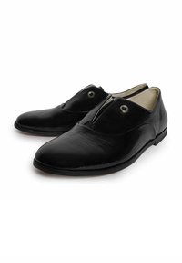 Zwarte leren schoenen met een sleek ontwerp, met een gladde textuur en een kenmerkende knoopsluiting op de voorkant. Platte zool en afgeronde neus.