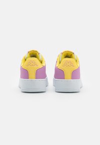 Baskets avec un dessus rose, des accents jaunes et une semelle en caoutchouc blanche ; présente un design cousu et un logo à l'arrière.