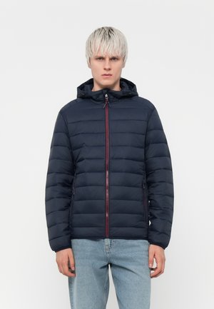Navy puffer jacket with a hood and red zipper. Made from smooth, quilted material, featuring side pockets and a fitted design.