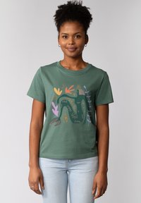 Grünes Baumwoll-T-Shirt mit einem bunten, abstrakten Blumenmuster in Lila, Orange und Gelb. Mit kurzen Ärmeln, runden Halsausschnitt und lässiger Passform.