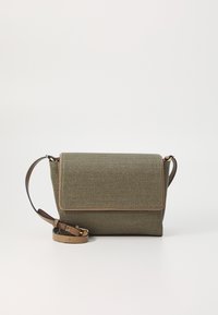 Green woven fabric bag with a fold-over flap, brown leather accents, and adjustable strap, featuring a textured surface and structured shape.
