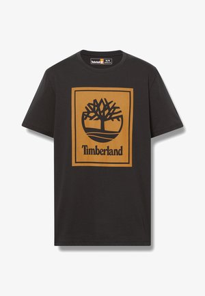 Czarny bawełniany t-shirt z dużym brązowym kwadratem i czarnym logiem drzewa oraz napisem "Timberland" na dole w pogrubionej czcionce. Klasyczny krój.