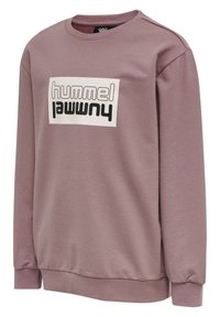 Sudadera púrpura con cuello redondo, mangas largas y cintura ajustada. Presenta un destacado logo gráfico en blanco y negro en la parte frontal.