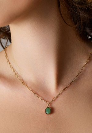 Gouden kettinghalsketting met langwerpige schakels, met een octagonale groene stenen hanger, gezet in een zwarte accent.