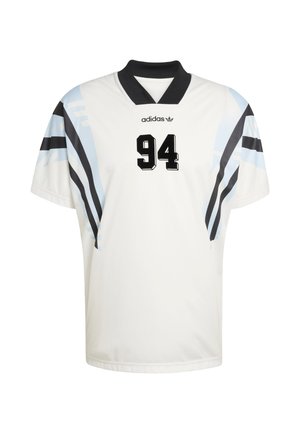 Biały sportowy trykot z krótkimi rękawami, czarnym kołnierzem oraz niebiesko-czarnymi skośnymi paskami. Numer „94” wyraźnie widoczny na czarno.