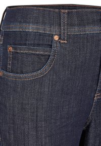 Dark blue denim jeans with a close-up view of the waistband, featuring copper stitching and a small front pocket detail.