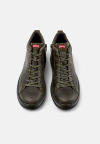 Oliwkowe skórzane sneakersy typu high-top z perforowanym noskiem, sznurowaniem i bocznym zamkiem błyskawicznym. Posiadają logo Camper na czerwonej naszywce.