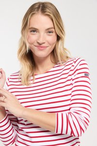 Hvid langærmet skjorte med røde vandrette striber. Har en rund halsudskæring og et lille logo-patch på venstre ærme. Blødt bomuldsstof.