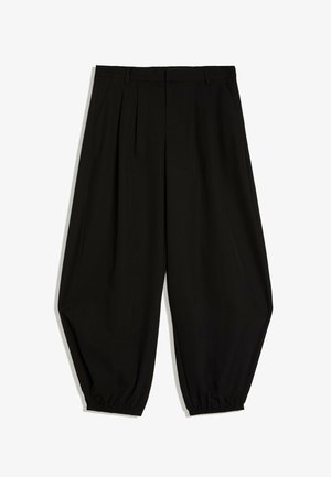 Zwarte broek met losse pasvorm, plooien, riemlussen, taps toelopende pijpen en elastische boorden.