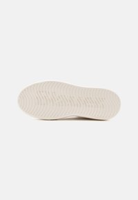 Suola di sneaker bianca con un motivo di battistrada ondulato, texture liscia, bordi leggermente rialzati e senza marchi o accenti visibili.