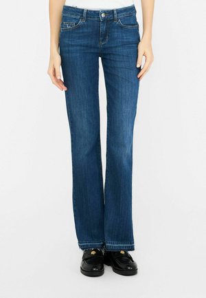 Flared blue denim jeans with a classic cut, featuring subtle whiskering, five-pocket design, and a button-fly closure.