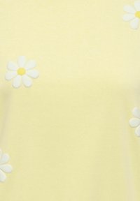 Material galben moale cu margarete albe brodate, având centre galbene, împrăștiate pe suprafață.