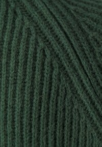 Filato verde scuro con un motivo a coste texturato, realizzato in fibre morbide, caratterizzato da una superficie leggermente pelosa e riflessi di luce variabili.