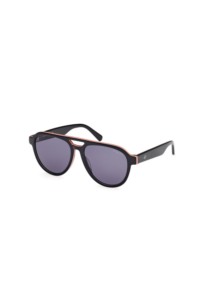 Occhiali da sole neri con lenti viola, dotati di una montatura nera audace e un accento arancione a contrasto lungo il bordo superiore, design elegante.