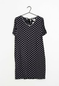 Granatowa, krótka sukienka z rękawami, z dekoltem w serek, z białym wzorem w trójkąty, z miękkiego materiału i z wstążką z tyłu dekoltu.